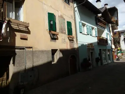 a building with green windows on a street at Casa Volcan in Tesero