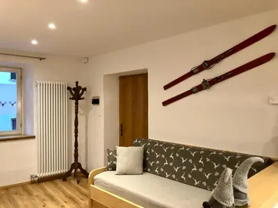 a living room with a couch and a window at Casa Volcan in Tesero