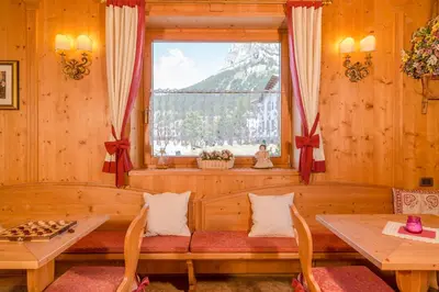 a room with a window and a table and chairs at Hotel Garni la Stua in Selva di Cadore