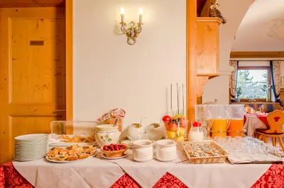 a table with food and drinks and plates on it at Hotel Garni la Stua in Selva di Cadore