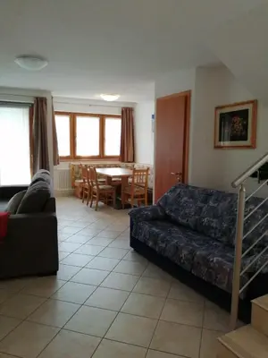 a living room with a couch and a table at Villetta Muncion in Pozza di Fassa