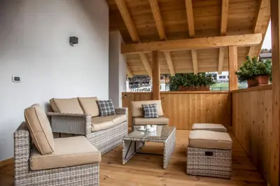 a living room with wicker chairs and a table at Editlodge 