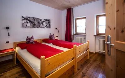 a bedroom with a large wooden bed with red sheets at Editlodge 