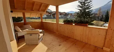 a wooden balcony with a couch and a christmas tree at Editlodge 