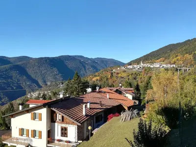 a house on a hill with mountains in the background at Maso Sveseri in Montesover