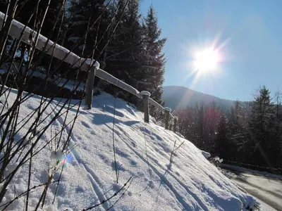 a snow covered hill with the sun in the sky at Maso Sveseri in Montesover