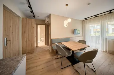 a kitchen and dining room with a wooden table and chairs at Art Residence Josefshof in Lagundo
