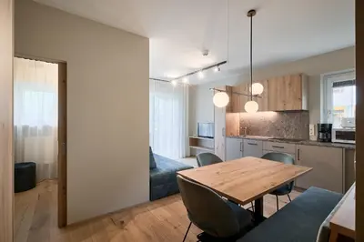a kitchen and dining room with a wooden table and chairs at Art Residence Josefshof in Lagundo