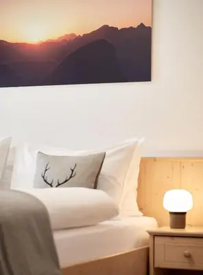 a bedroom with a bed with a picture on the wall at Residence Settsass in Colfosco