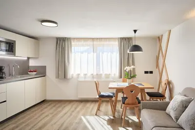 a kitchen and living room with a table and chairs at Residence Settsass in Colfosco