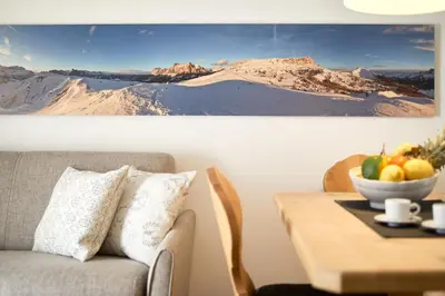 a living room with a couch and a table with a bowl of fruit at Residence Settsass in Colfosco