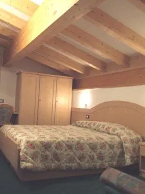 a bedroom with a bed in a room with wooden ceilings at DOLOMITI appart&rooms in Varena