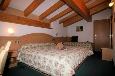 a bedroom with a bed with a teddy bear on it at DOLOMITI appart&rooms in Varena