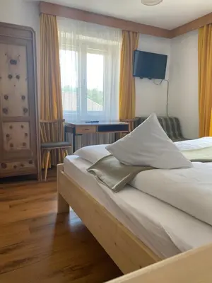 a bedroom with two beds and a desk and a window at Ciasa Soreghina in Colfosco