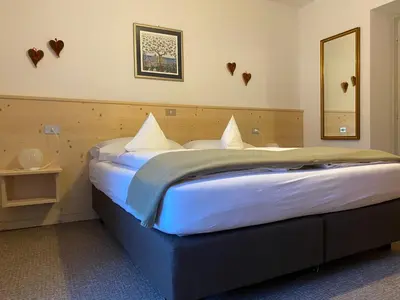 a bedroom with a large bed with white pillows at Ciasa Soreghina in Colfosco