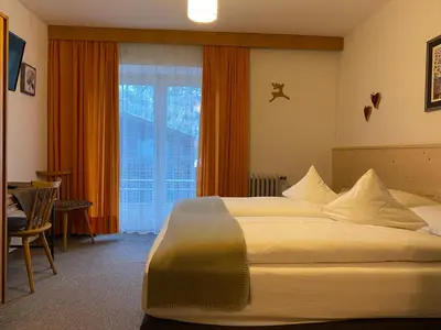 a hotel room with a large bed and a window at Ciasa Soreghina in Colfosco