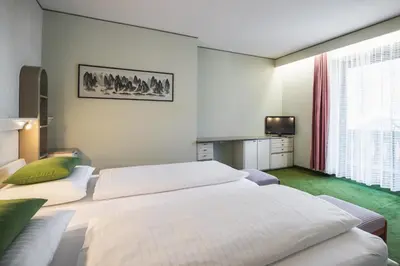 a hotel room with two beds and a television at Kronplatz Lodge Dolomites in San Vigilio Di Marebbe