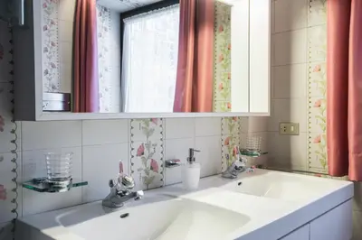 a bathroom with two sinks and a mirror at Kronplatz Lodge Dolomites in San Vigilio Di Marebbe