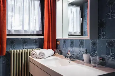 a bathroom with a sink and a mirror and a radiator at Kronplatz Lodge Dolomites in San Vigilio Di Marebbe