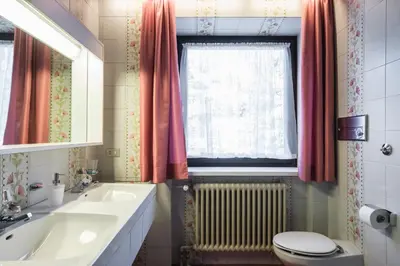 a bathroom with a tub and a toilet and a sink at Kronplatz Lodge Dolomites in San Vigilio Di Marebbe
