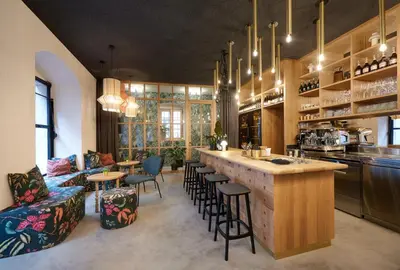 a kitchen with a bar and some chairs and tables at Goldengel Design - Suiten im historischen Ortskern von Kaltern in Caldaro