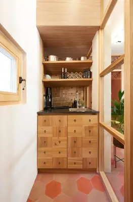 a kitchen with a wooden cabinet in a room at Goldengel Design - Suiten im historischen Ortskern von Kaltern in Caldaro