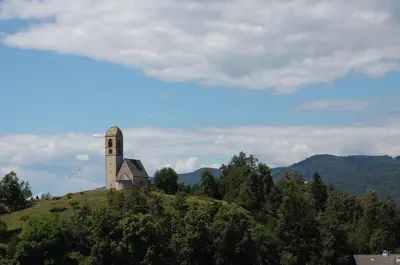 a church on top of a hill with trees at Dolomitica, nuovo, fino a 6 Persone in Vols am Schlern