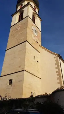 a tall tower with a clock on a building at Dolomitica, nuovo, fino a 6 Persone in Vols am Schlern