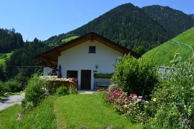 a house with a green hill in the background at Martlerhof Urlaub auf dem Bauernhof in Campo di Trens