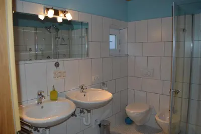a bathroom with two sinks and a toilet at Martlerhof Urlaub auf dem Bauernhof in Campo di Trens
