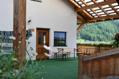 a patio with a table and a wooden roof at Martlerhof Urlaub auf dem Bauernhof in Campo di Trens