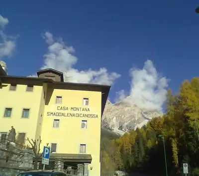 a building with a sign on the side of it at Casa Montana S. Maddalena in San Vito di Cadore