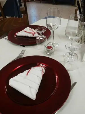 a red plate with napkins on a table with wine glasses at Casa Montana S. Maddalena in San Vito di Cadore