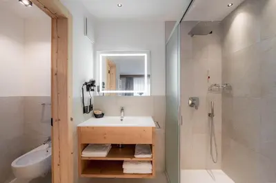 a bathroom with a sink and a shower at Spires Hotel in Canazei