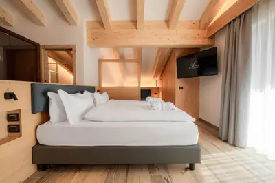 a bedroom with a large white bed in a room at Spires Hotel in Canazei