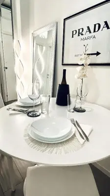 a white table with a plate and glasses on it at Chic In The City in Bolzano