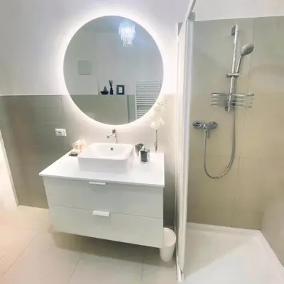 a bathroom with a sink and a shower with a mirror at Chic In The City in Bolzano