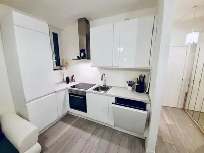a small kitchen with white cabinets and a sink at Chic In The City in Bolzano