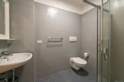 a bathroom with a toilet and a sink and a shower at Laubenapartment in Merano
