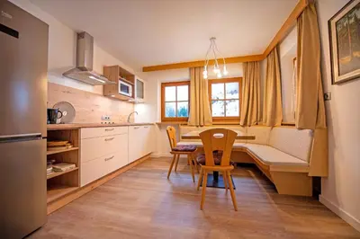 a kitchen with a table and chairs in a room at Chalet Alpina in Ortisei