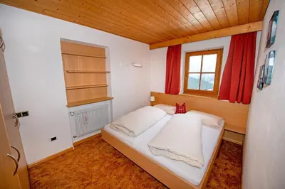 a small bed in a room with a window at Chalet Alpina in Ortisei