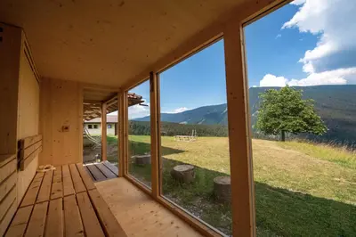 a view from the porch of a house with large windows at Chalet Alpina in Ortisei