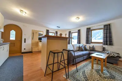 a kitchen and living room with a couch and a table at Chalet Alpina in Ortisei