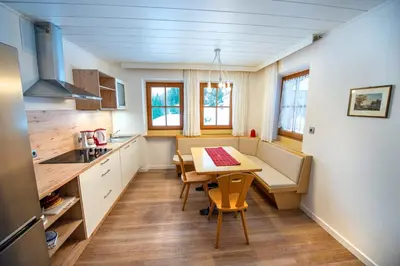 a kitchen with a table and chairs in a room at Chalet Alpina in Ortisei