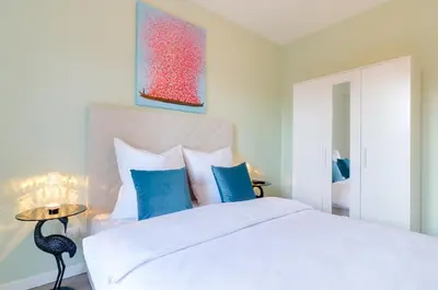 a bedroom with a white bed with blue pillows at Penthouse Jolanda Meran-o in Merano