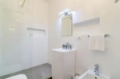 a white bathroom with a sink and a mirror at Penthouse Jolanda Meran-o in Merano