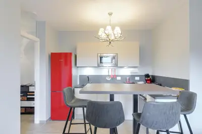 a kitchen with a table and chairs and a red refrigerator at Penthouse Jolanda Meran-o in Merano