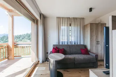 a living room with a couch and a large window at Lochbauer in Meltina