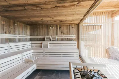 an empty sauna with wooden walls and benches at Lochbauer in Meltina