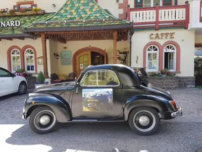 an old car parked in front of a building at Albergo Bernard in Canazei